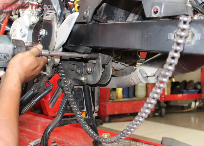 Teknisi memeriksa dan menyetel rantai motor yang mulai kendor β imgx.gridoto.com